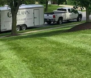 Oak Lawn Landscaping’s commercial lawncare truck and trailer are parked on the street, ready for work