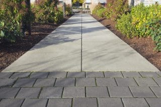 A professionally designed walkway. The walkway uses durable, slip-resistant materials and has a concrete and brick design.